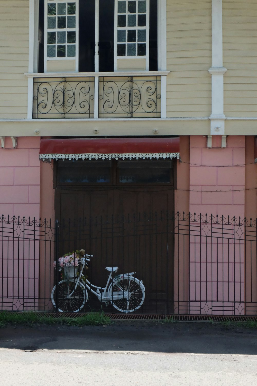 a bicycle parked in front of a pink building