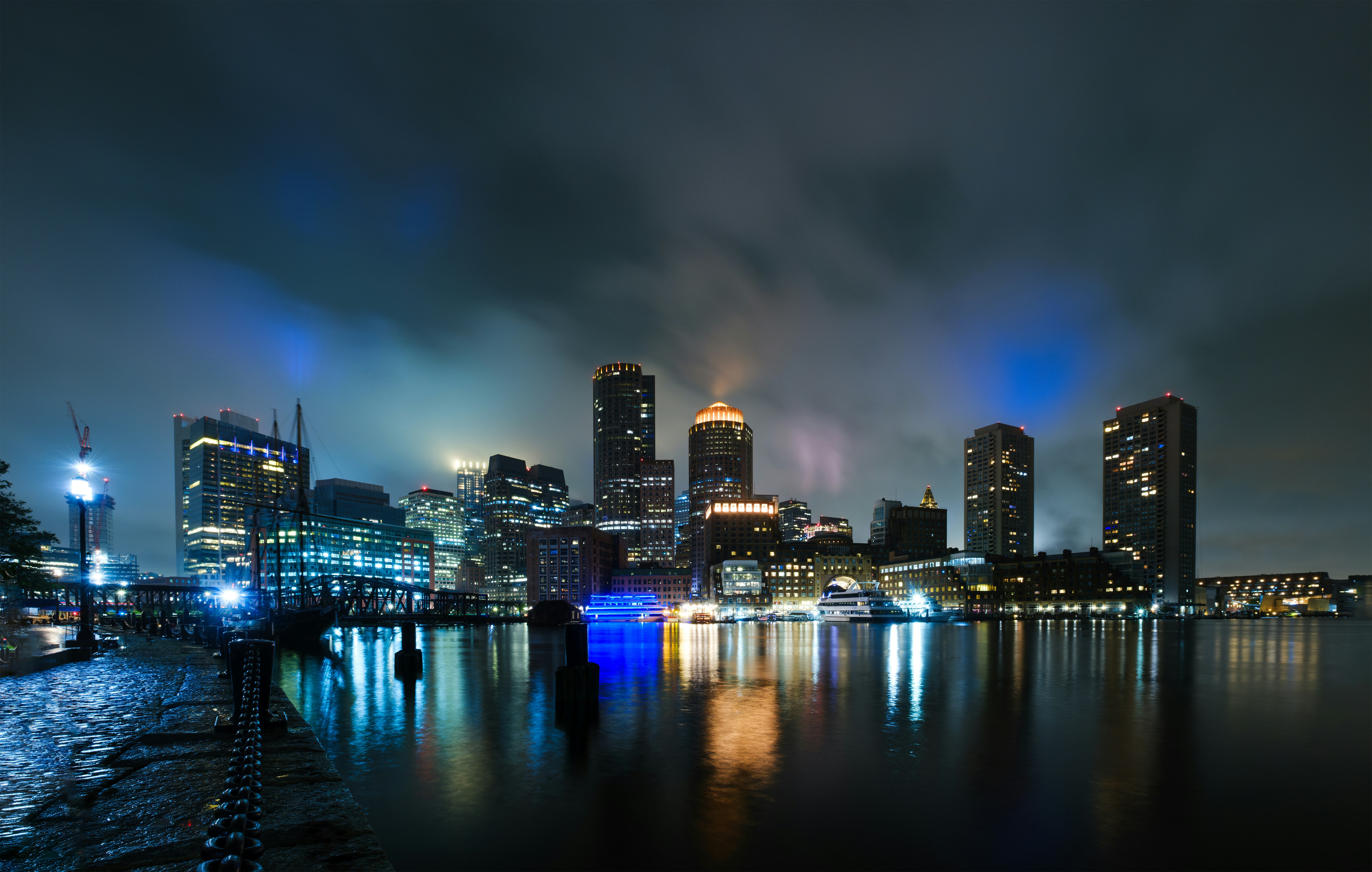 a city skyline at night with lights reflecting in the water