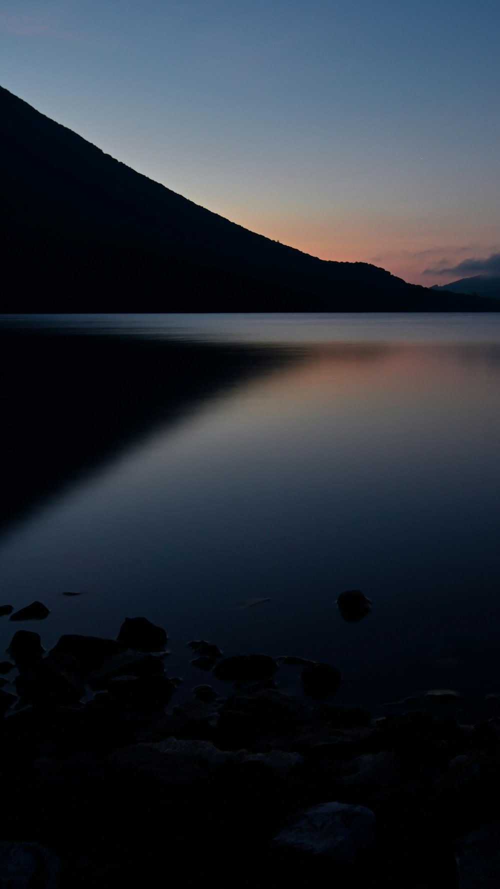 a large body of water with a mountain in the background