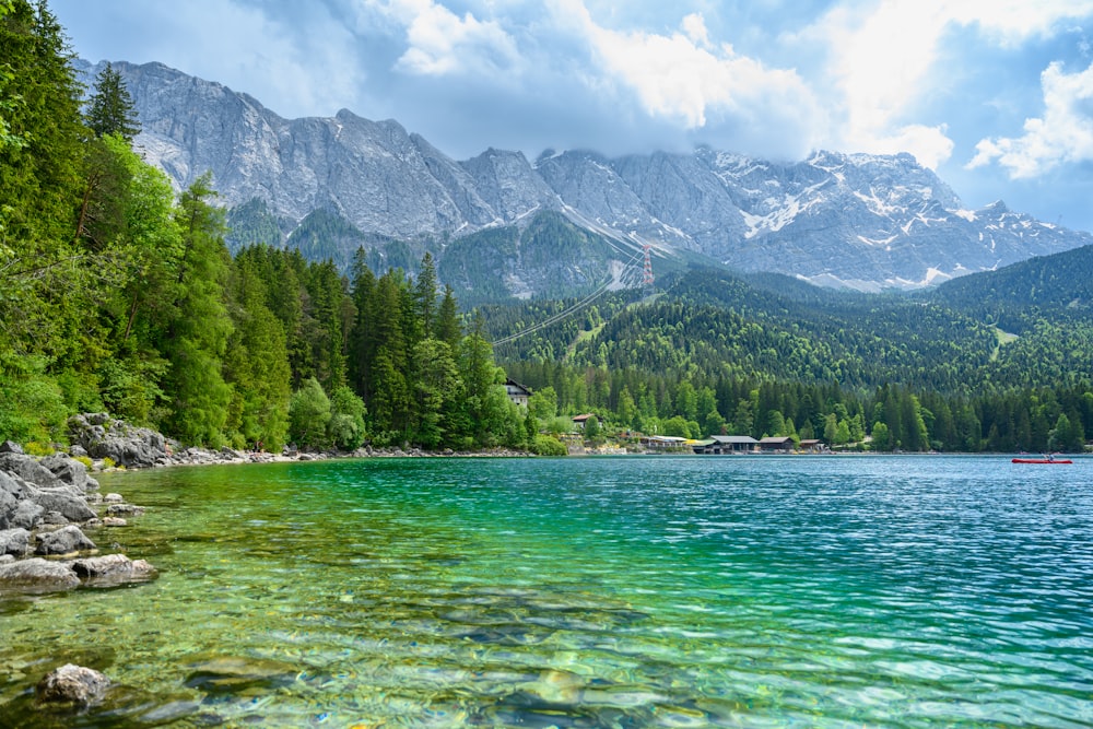 a body of water surrounded by trees and mountains