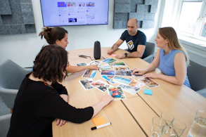 a group of people sitting around a wooden table