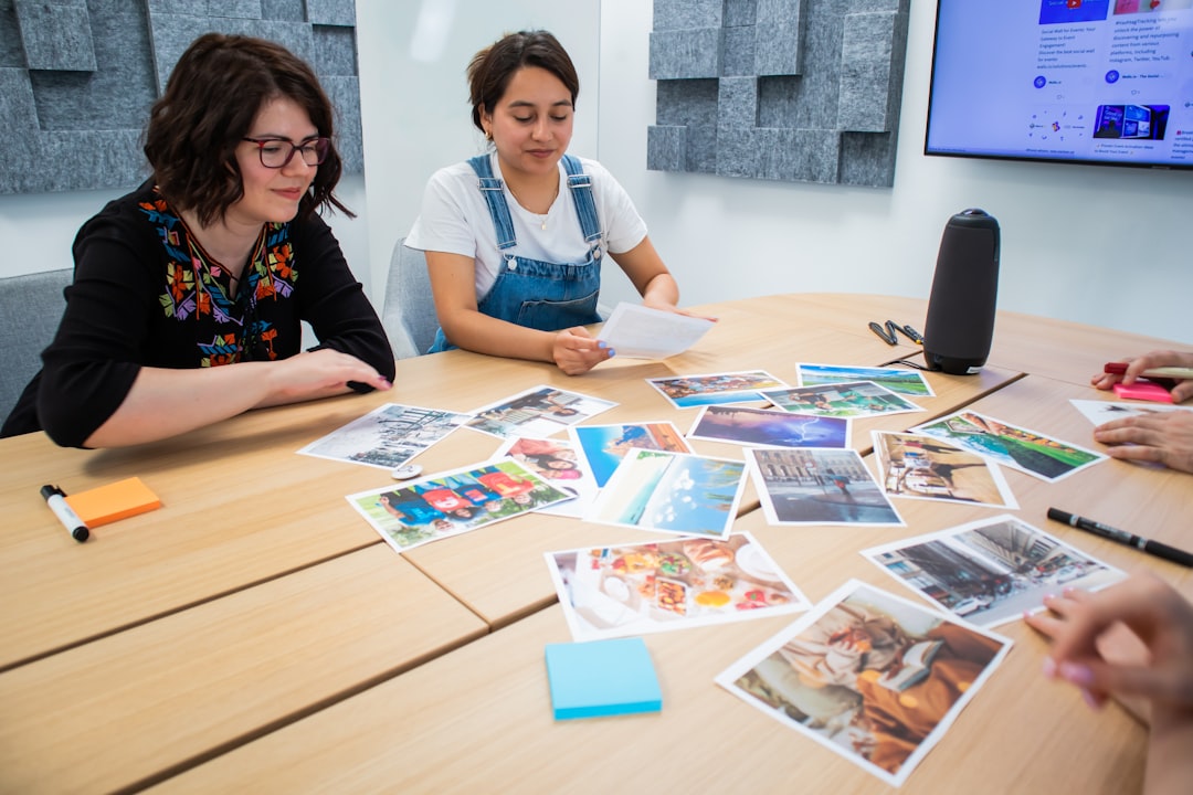 a group of people sitting around a wooden table, Team members playing an employee engagement game in a team building activity