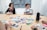 A group of professionals reviewing stationery samples around a conference table.