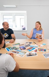 a group of people sitting around a wooden table