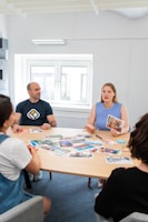 a group of people sitting around a wooden table