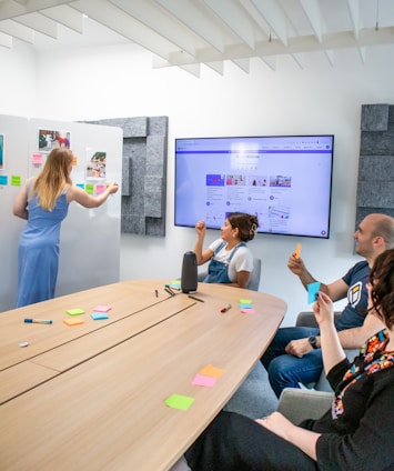 a group of people sitting around a wooden table