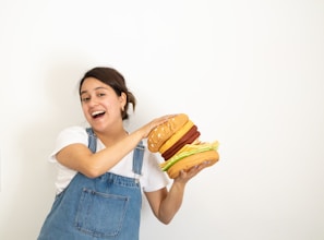 A family posing happily with dinosaur hats and holding their burger meals.