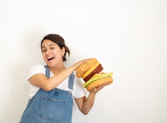A family posing happily with dinosaur hats and holding their burger meals.
