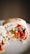 A close-up view of a burrito cut in half, displaying its colorful filling. Inside the burrito, there is visible white rice, fresh greens, red bell peppers, and purple beans, all wrapped in a tortilla. The ingredients appear fresh and vibrant, and the tortilla has a slight char.