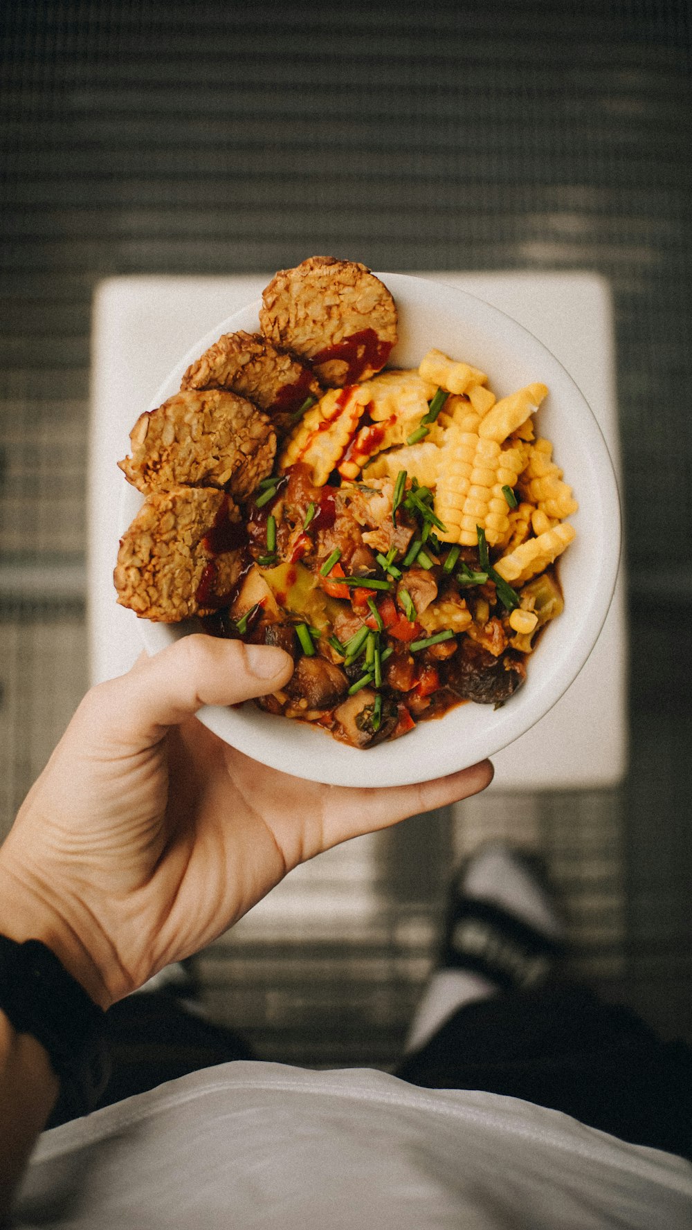 a person holding a plate of food in their hand