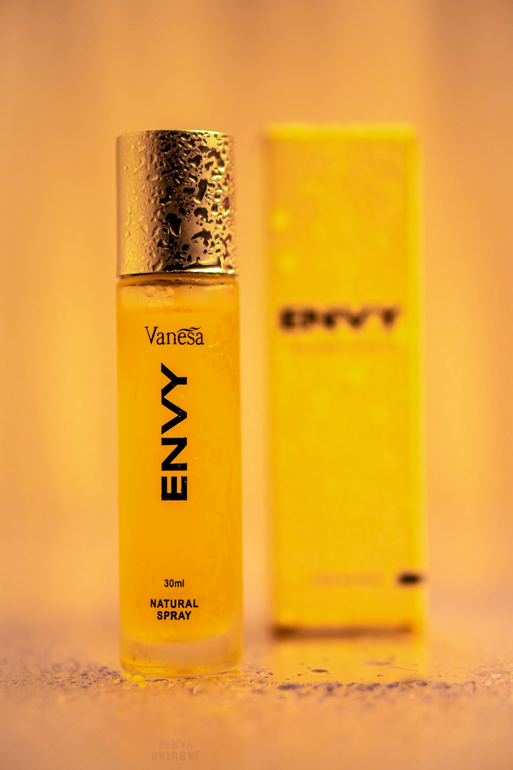 a bottle of envy next to a yellow box