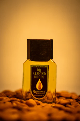 Close-up of a hand applying bhringraj hair oil on shiny, healthy hair in natural light