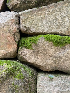 Stacks of vibrant green stone slabs neatly arranged in a sunlit quarry.