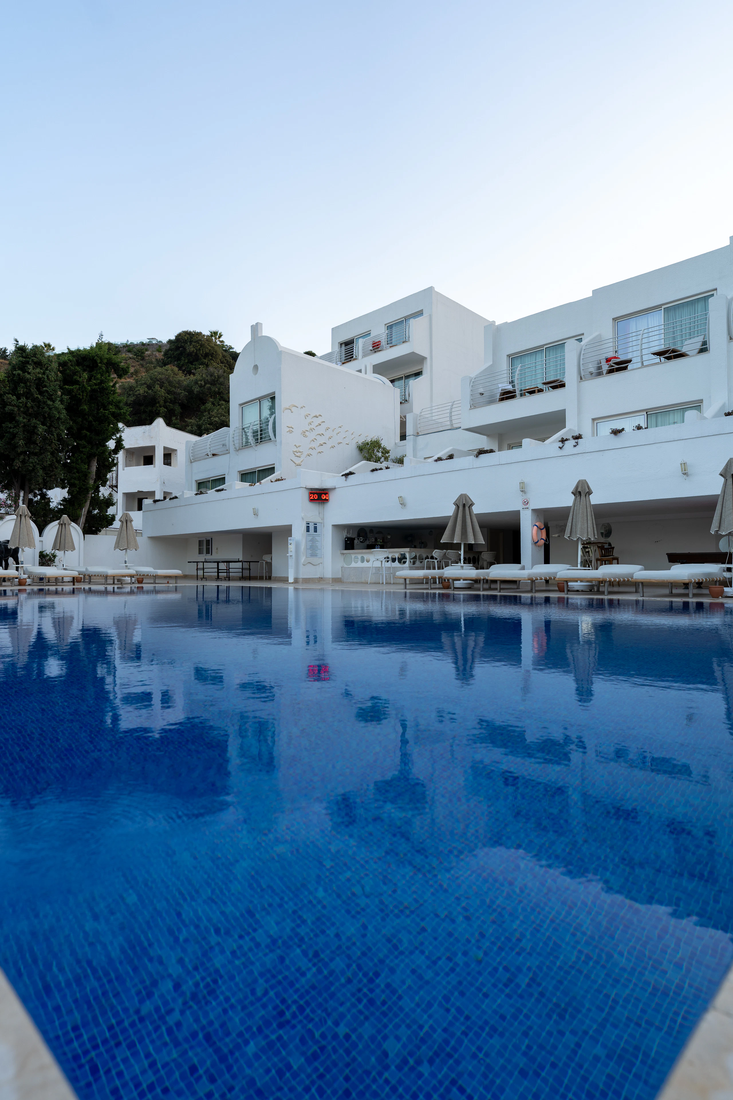 Luxury villa in Greece with a large edge swimming pool and white architecture, kept spotless by Icarus Management housekeeping