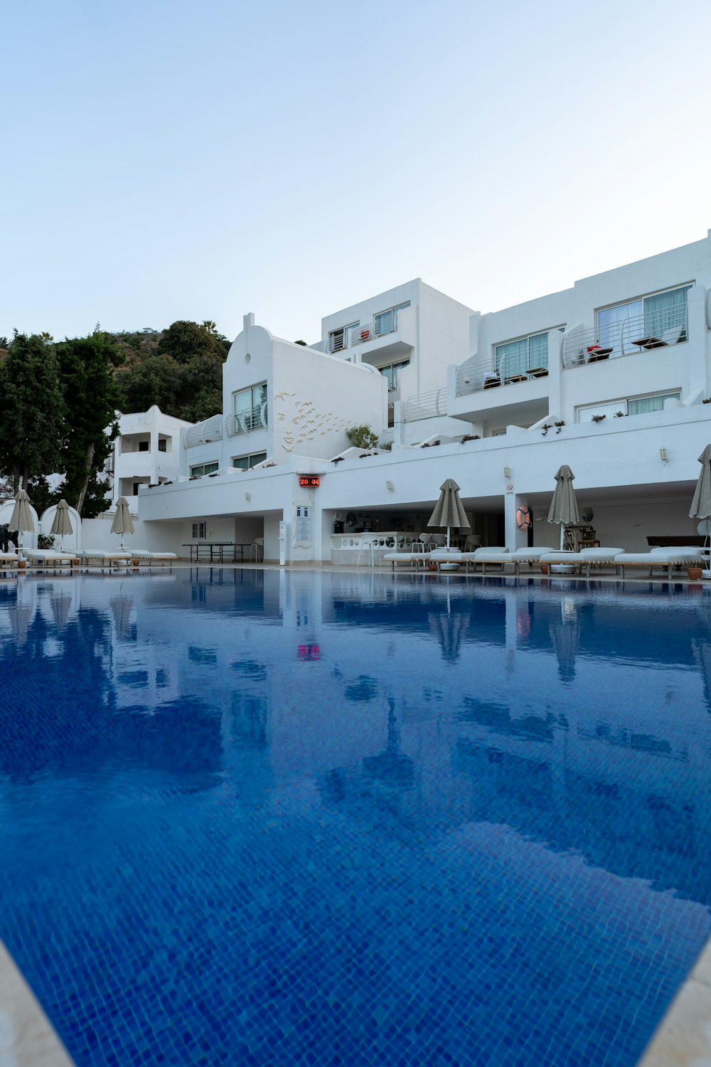 a large swimming pool in front of a white building