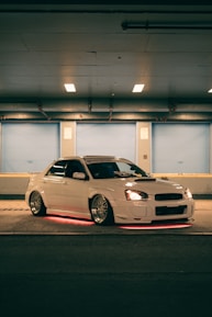 Vibrant shot of a customized car with oversized subwoofers illuminated by colorful lights.
