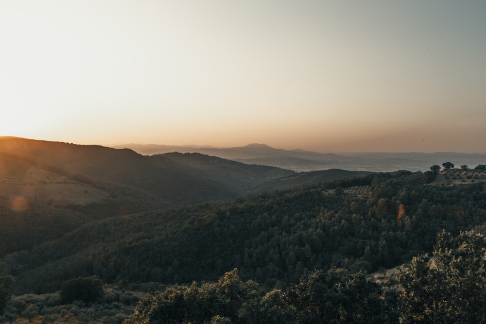 the sun is setting over a mountain range