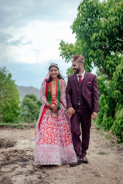 A serene outdoor scene with a couple walking hand in hand in traditional attire.