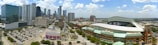 A panoramic view of a city skyline with a football pitch.