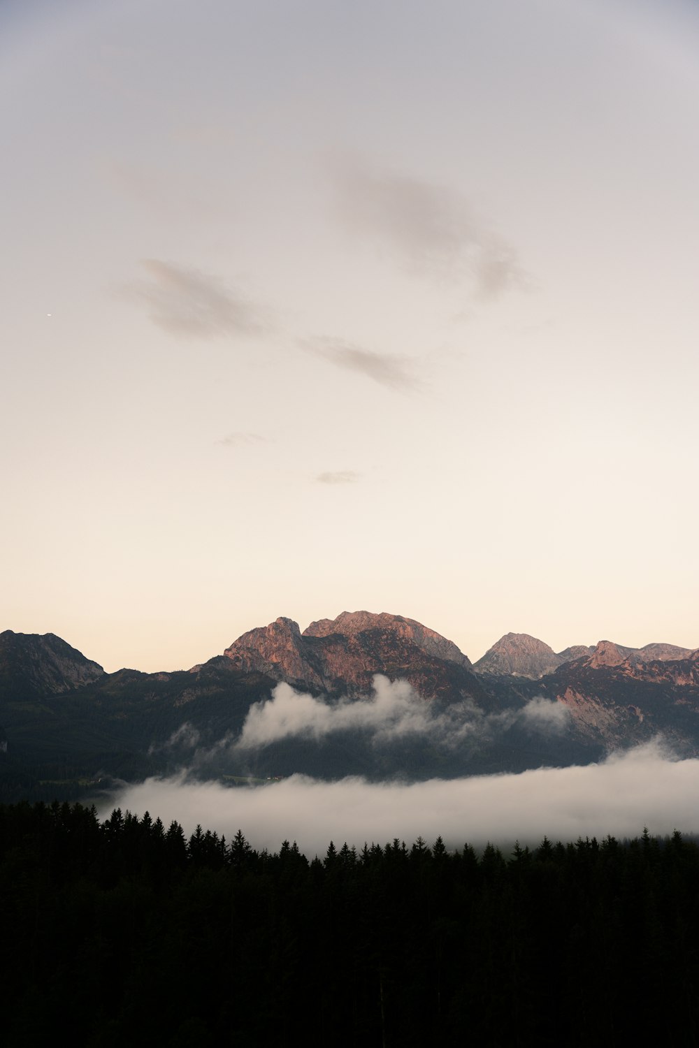 a view of a mountain range with low lying clouds