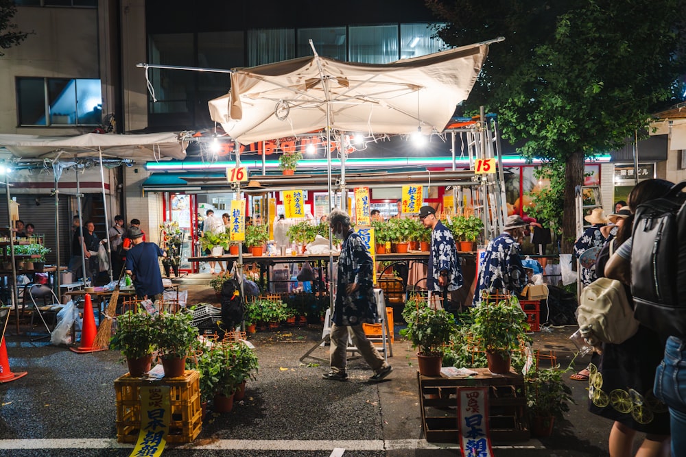 a group of people standing outside of a store at night