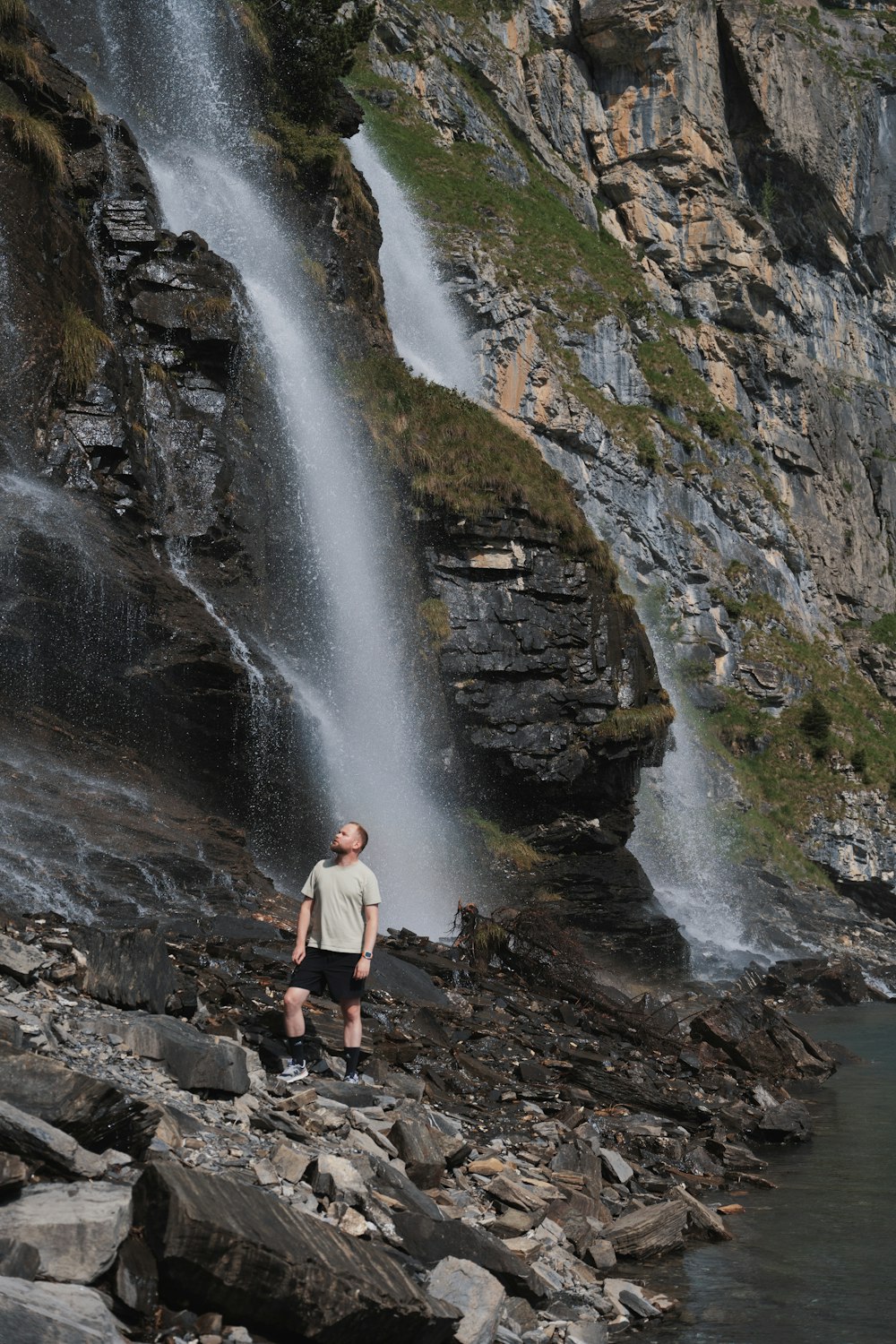 a man standing in front of a waterfall