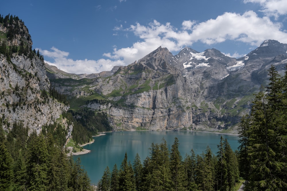 a mountain range with a lake surrounded by trees