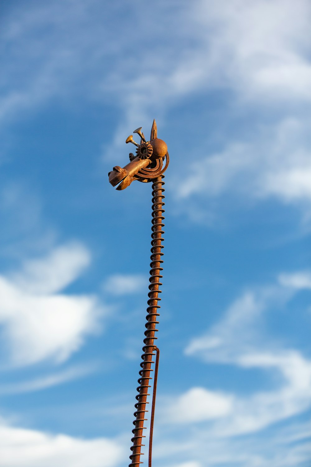 a statue of a man riding a horse on top of a tall pole