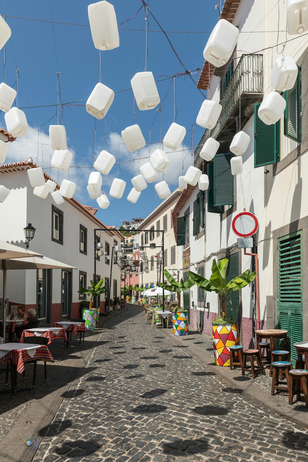 a cobblestone street lined with tables and chairs