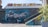 A large mural of a seal, painted with vivid colors against a stone wall. Above the mural, a sign spells out 'I ❤️ CÂMARA DE LOBOS' in bright yellow letters. A person is standing in front of the mural with their arms raised. A flight of stairs is on the right, with additional artwork of yellow and blue sea creatures painted along the side.