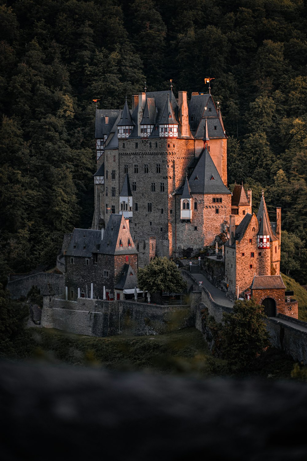 Un antiguo castillo con muchas ventanas en la cima de una colina