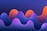 A digital abstract artwork featuring smooth, wave-like shapes in a gradient of vibrant colors. The waves transition from deep violet and blue at the bottom to bright orange and pink at their peaks, against a dark blue background.