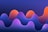 A digital abstract artwork featuring smooth, wave-like shapes in a gradient of vibrant colors. The waves transition from deep violet and blue at the bottom to bright orange and pink at their peaks, against a dark blue background.