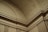 Ornate architectural details featuring intricate moldings and geometric patterns on a curved interior ceiling and wall.