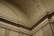 Ornate architectural details featuring intricate moldings and geometric patterns on a curved interior ceiling and wall.
