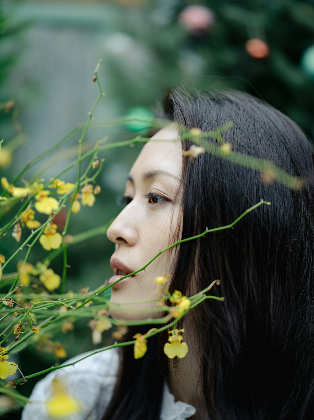 Una mujer con cabello largo y negro y flores en la boca