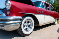 A classic antique car parked outside the Ironbucket shop under a bright Montana sky.