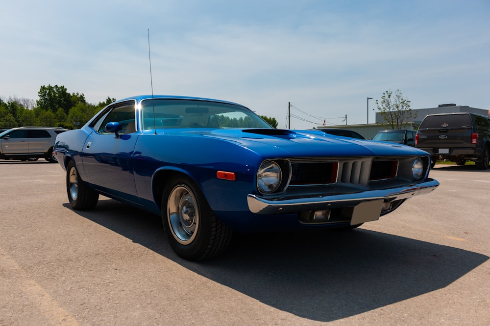 a blue muscle car parked in a parking lot