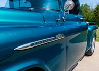 A close-up of the truck's cherry red paint shining in the sun.