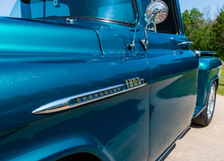 A gleaming blue truck freshly detailed under bright sunlight, showcasing a mirror-like finish.