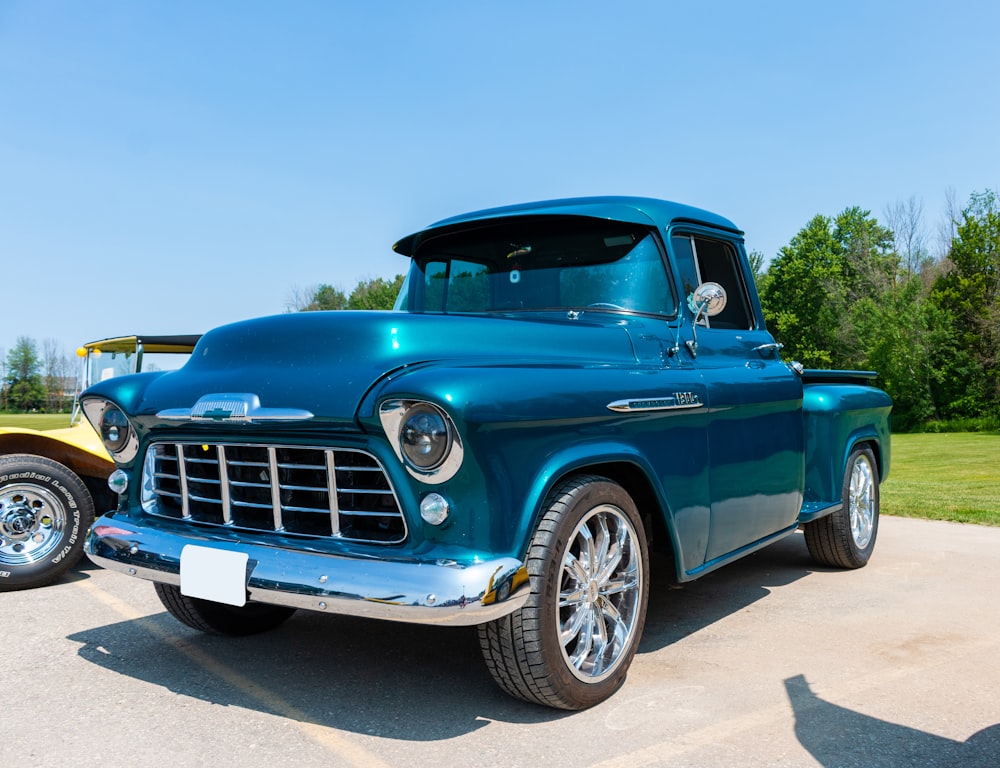 a blue truck parked in a parking lot next to another truck