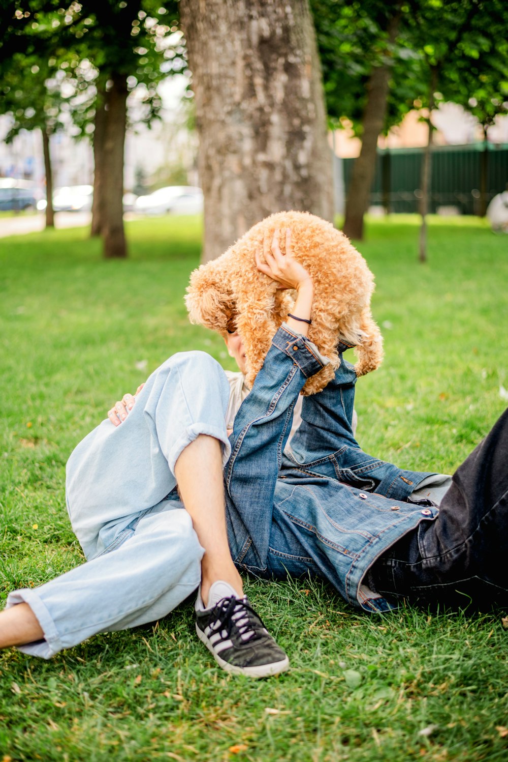 a person laying in the grass with a teddy bear
