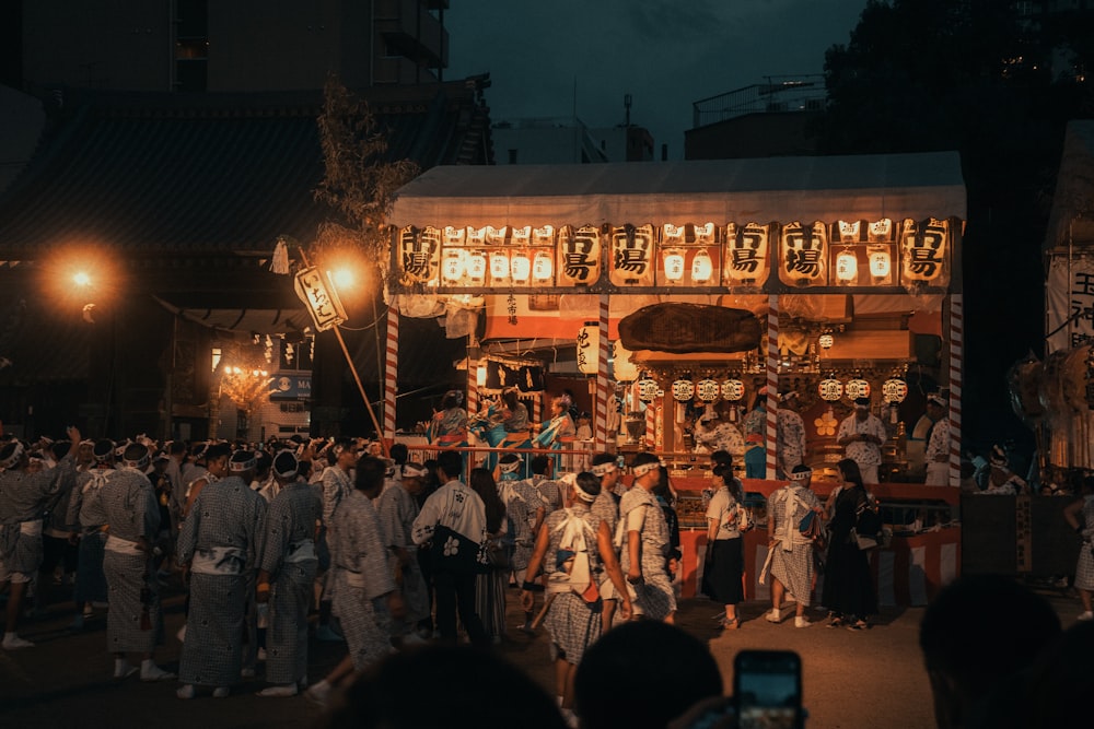 a group of people standing around a building at night