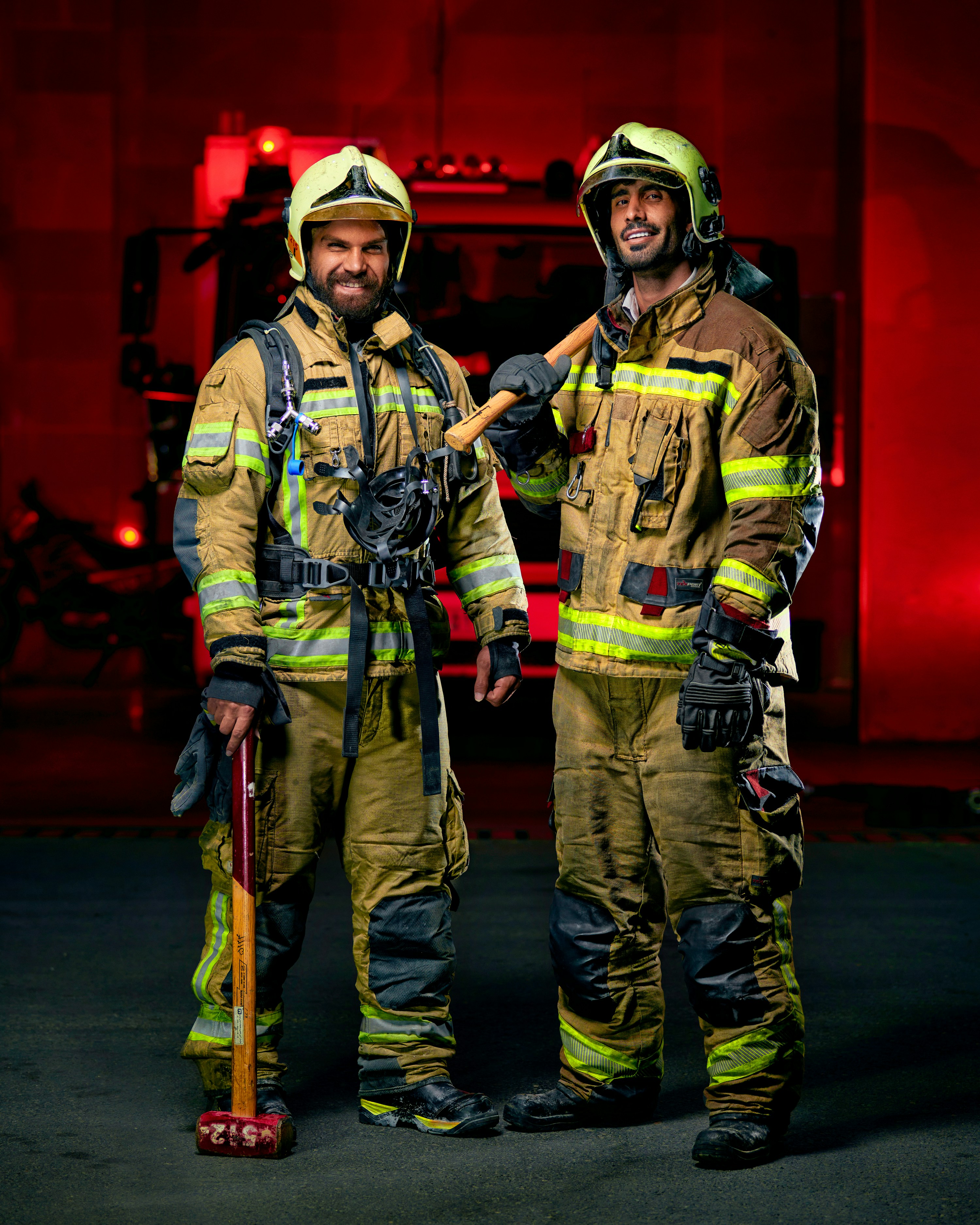 a couple of fire fighters standing next to each other