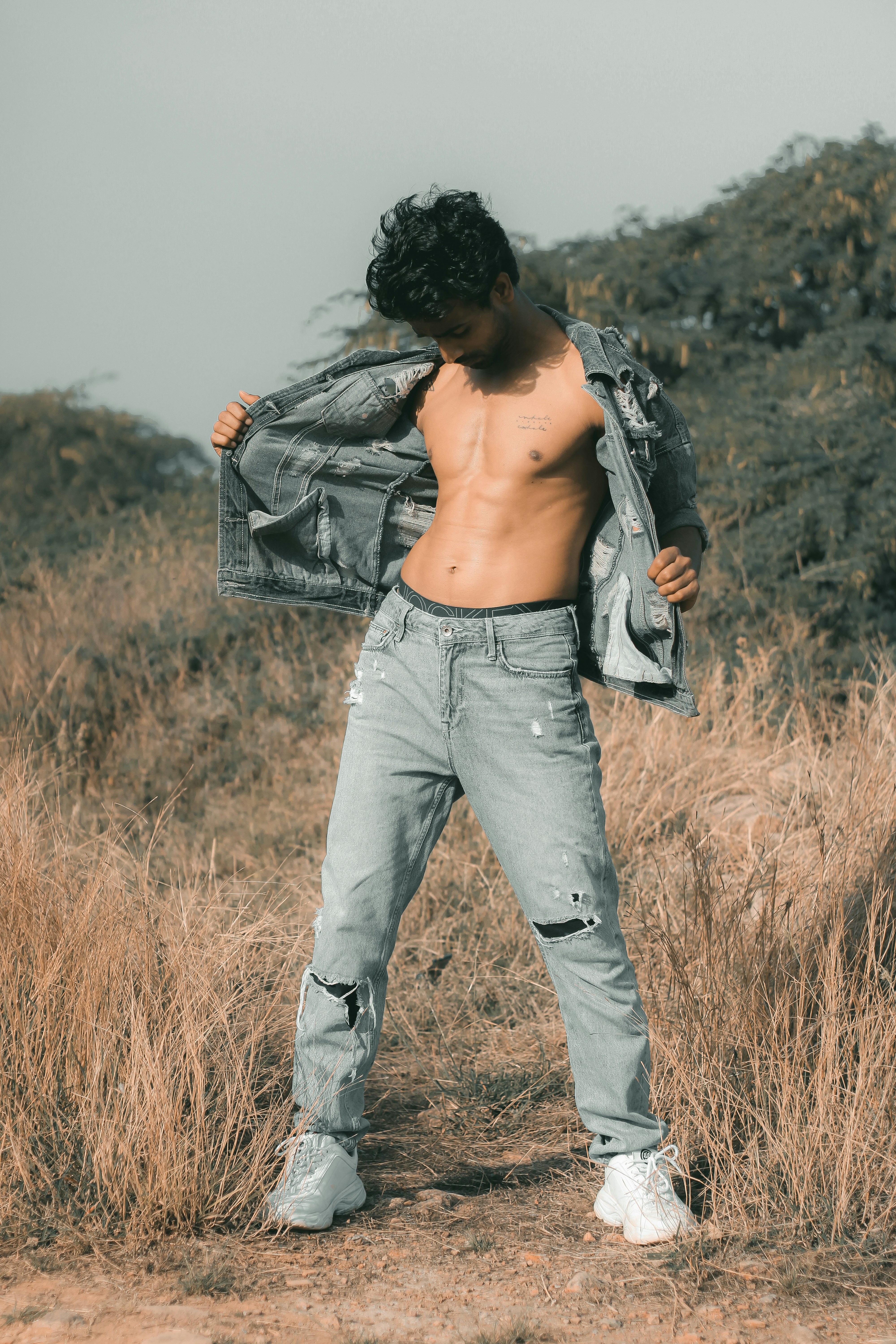 Un hombre sin camisa sin camisa parado en un campo