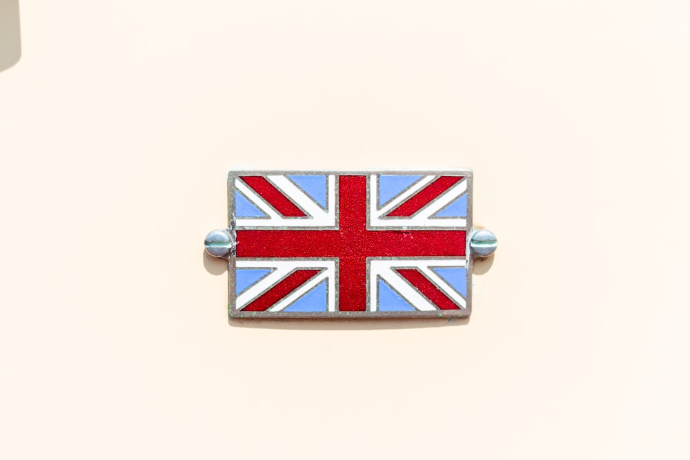 a british flag pin sitting on top of a white wall