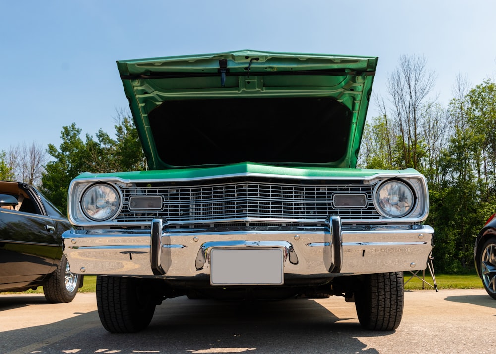 an old car with its hood open in a parking lot