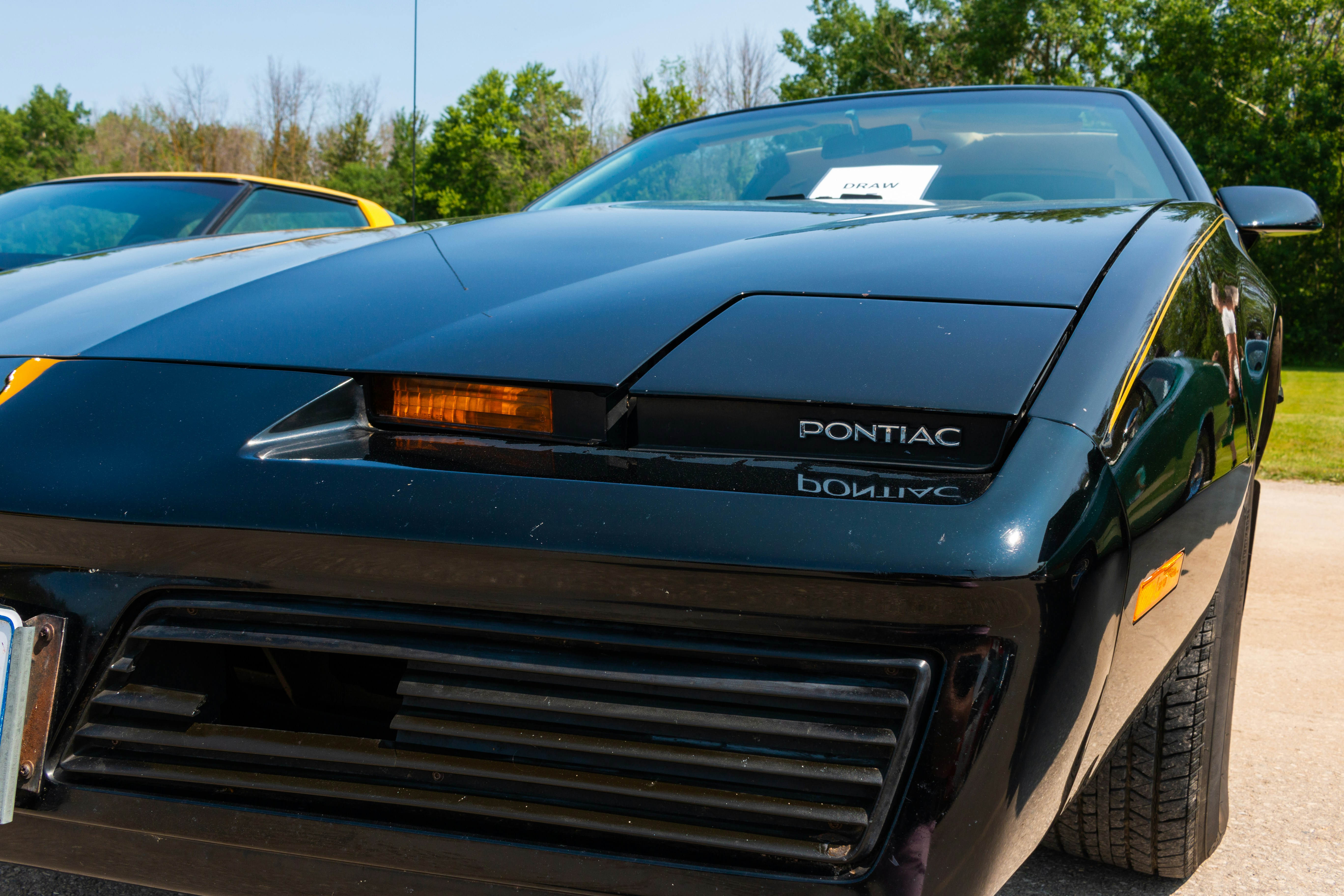 A black sports car parked next to a yellow sports car photo Free