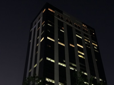 Evening view of the office building lit warmly, symbolizing dedication.