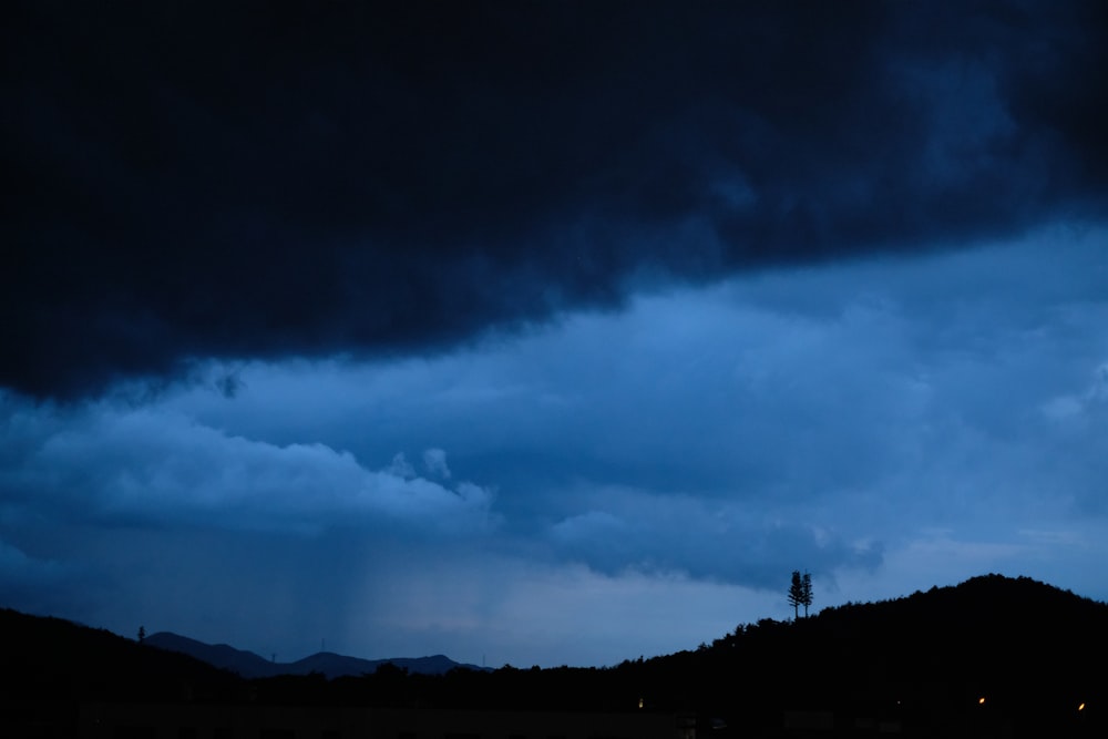 a dark sky with dark clouds above a mountain